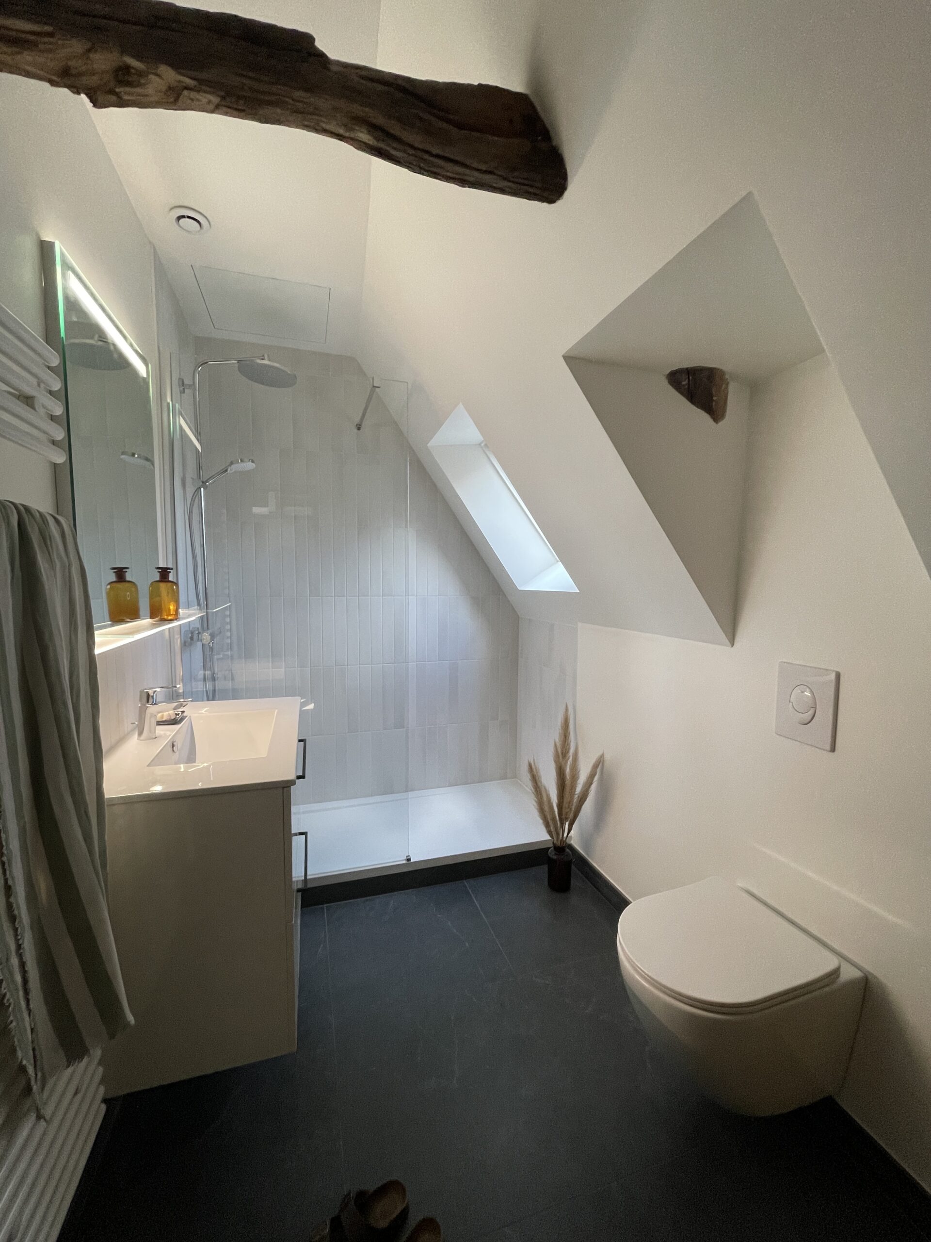 BARS – Salle de bain rénovation appartement rennes. Travaux de plomberie et électricité réalisés dans une salle d'eau avec WC suspendu, meuble vasque, douche avec receveur extra plat, éclairage